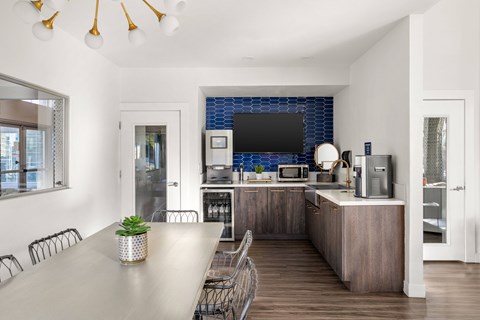 a kitchen and dining room with a table and chairs and a television